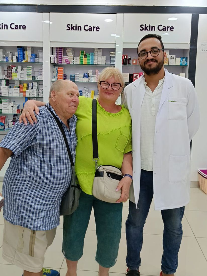 A couple with our pharmacist in the skin care aisle